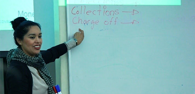 woman smiling and pointing to a white board